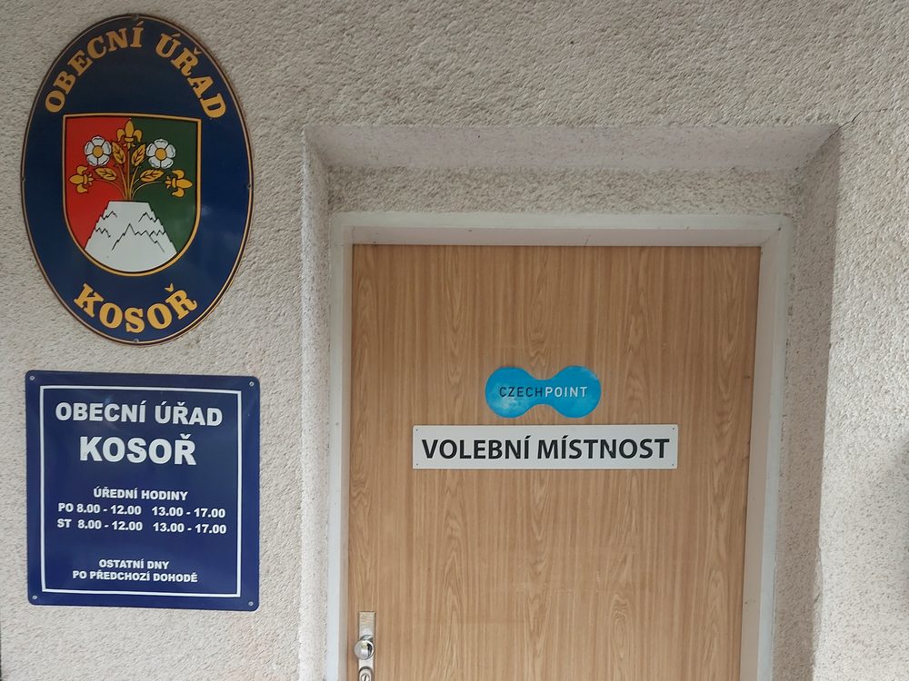 Vchod do volební místnosti – dveře obecního úřadu Kosoř s cedulí Volební místnost